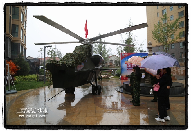 小區(qū)突然出現(xiàn)“飛機坦克”，其中殲15艦載戰(zhàn)斗機一架、99式主戰(zhàn)坦克一輛、武直-10武裝直升機一架，吸引了眾多市民雨中圍觀、合影。